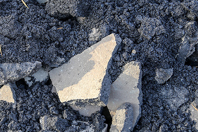Aufgebrochener schwarzer Asphalt von Straßenbau