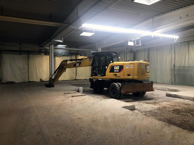 Große Baugrube mit freiliegenden Betonfundamenten in Produktionshalle