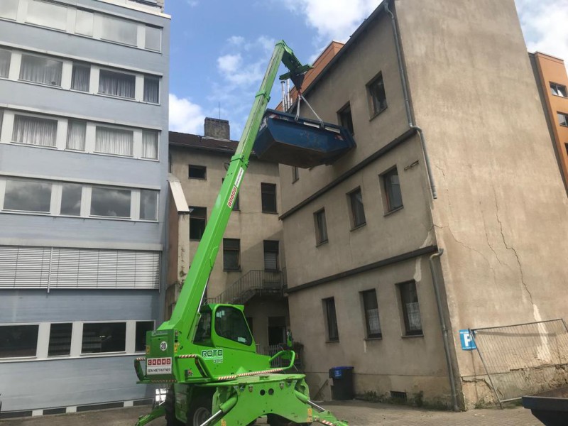 Abbrucharbeiten an einem Gebäude mit Baggereinsatz und Schuttbergen