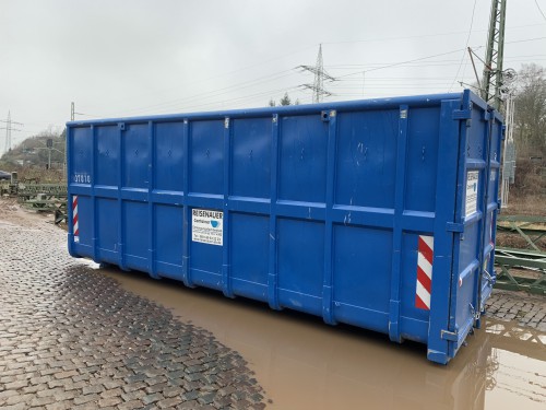 Seitenansicht eines großen blauen Abrollcontainers mit einer Beschriftung 'Reisenauer Container'