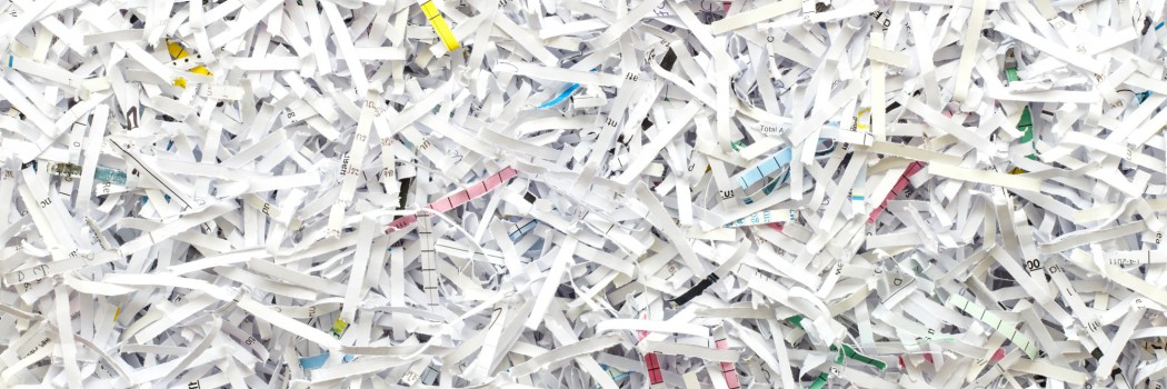 Kleine weiße Papierschnipsel von geschredderten Dokumenten