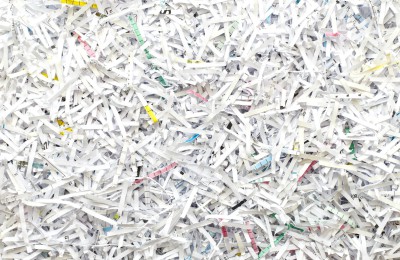 Kleine weiße Papierschnipsel von geschredderten Dokumenten