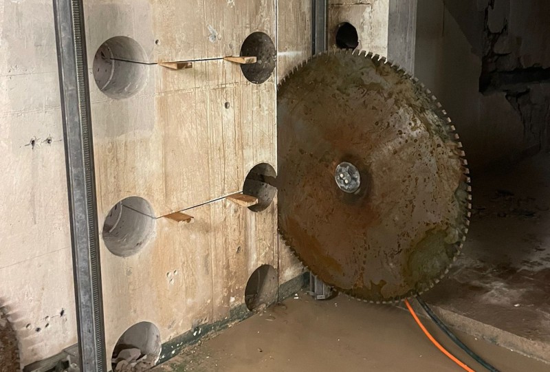 Diamantsäge schneidet durch eine Betonwand mit Funkenfug