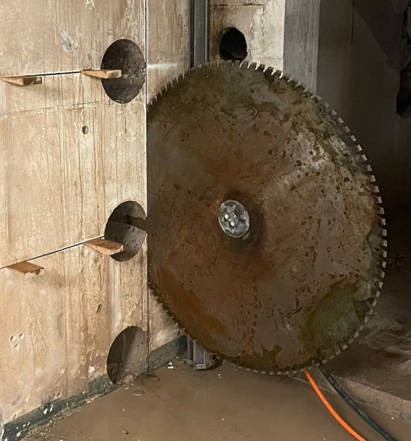 Diamantsäge schneidet durch eine Betonwand mit Funkenfug