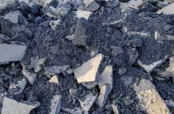 Aufgebrochener schwarzer Asphalt von Straßenbau